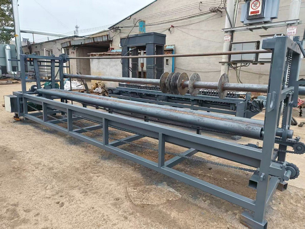 Front view of a gabion mesh roll winding machine with its long winding frame and mandrels