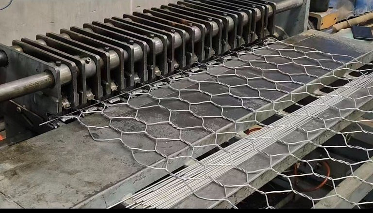 Close-up of a gabion mesh selvedge crimping machine folding the edge of hexagonal mesh
